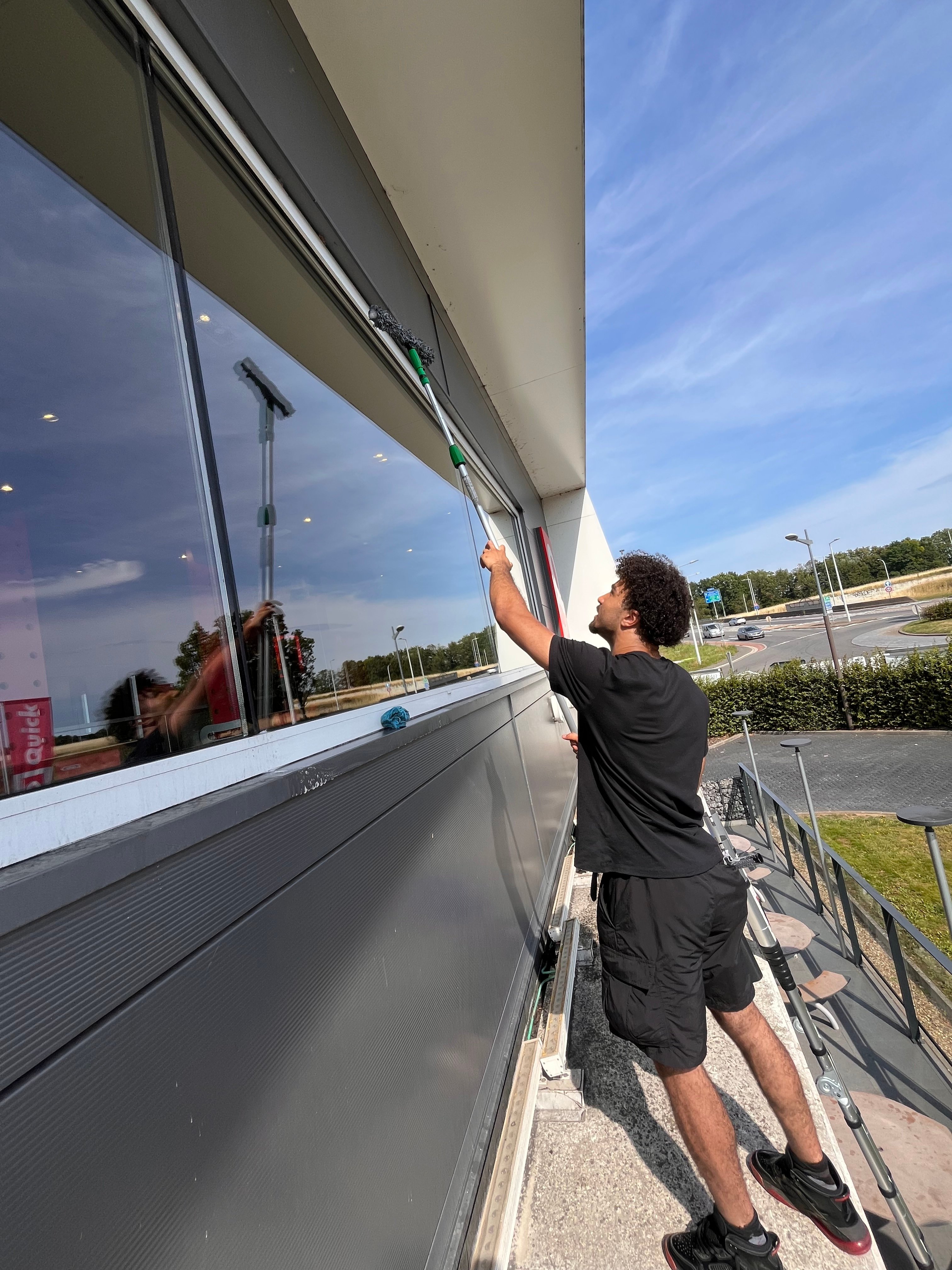 Laveur de vitres à Verviers nettoyant une grande baie vitrée