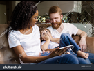 https://www.noelshack.com/2024-38-5-1726849464-stock-photo-happy-couple-of-black-woman-and-white-man-sitting-on-the-sofa-with-their-son-woman-holding-tablet-648983335.jpg